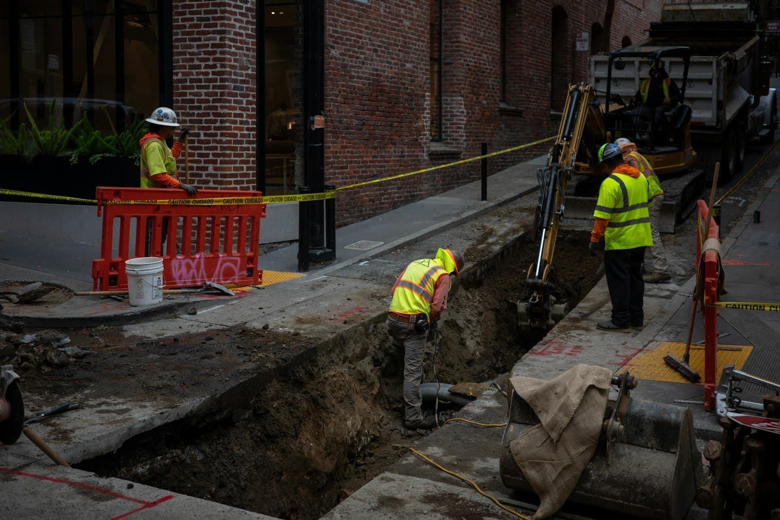 Construction workers digging a trench in a city street