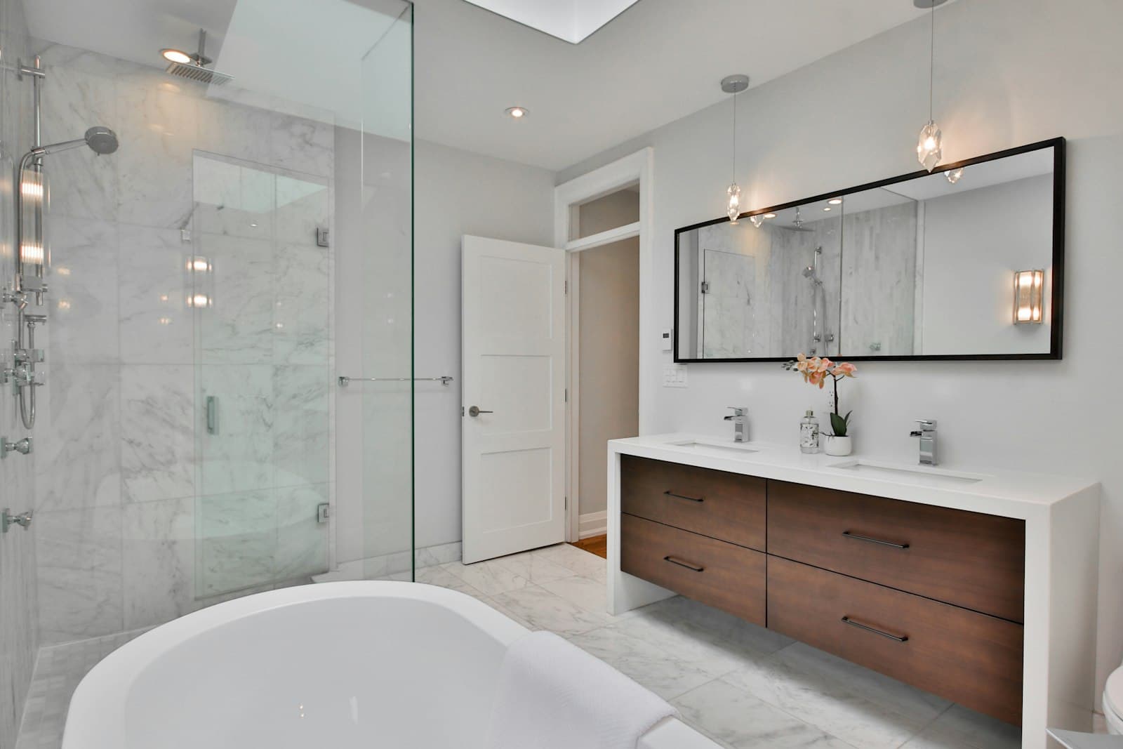 A remodeled bathroom with a freestanding tub and walk-in shower